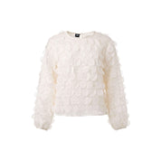 Semi-sheer blouse with 3D dots that create a playful texture. Round neckline with a back closure.